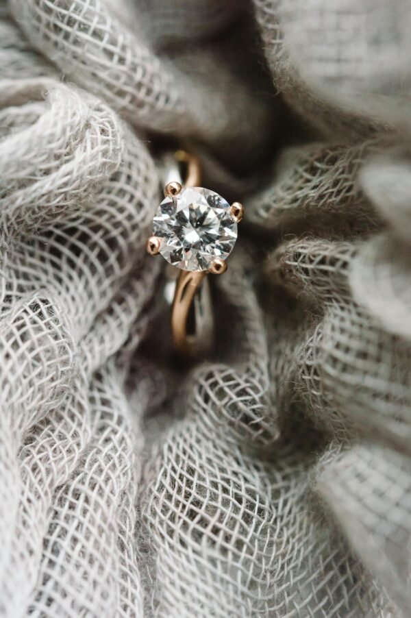 Close-up view of a sparkling diamond ring set against textured fabric, showcasing elegance and style.