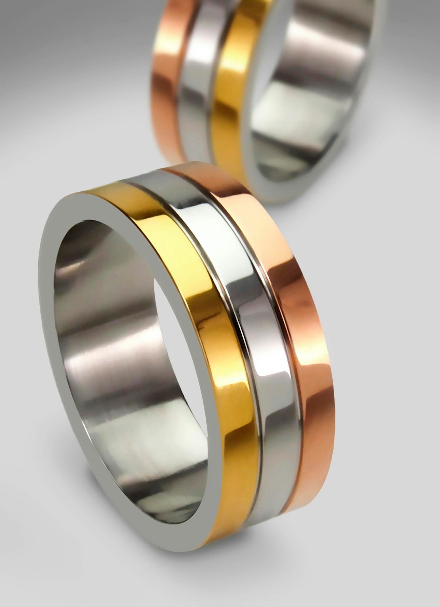 Elegant tri-color gold rings showcasing modern design, perfect for engagements or weddings.